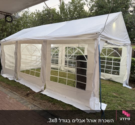 אוהל לבן גדול עם חלונות שקופים באירוע חיצוני